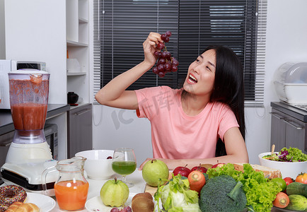 在厨房里吃葡萄的女人