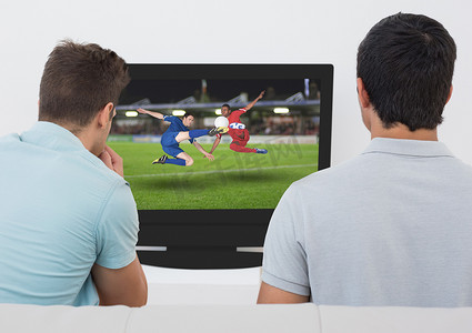 在电视上看足球比赛的男人的后视图