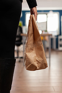 女商人在外卖午餐时间拿着送货外卖食品餐单纸袋