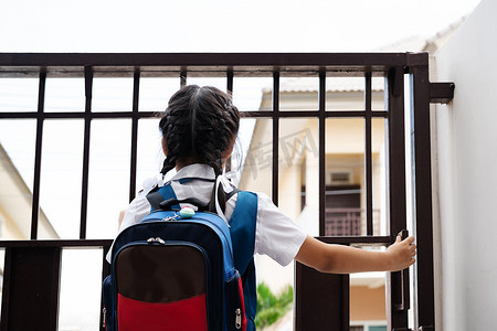 穿制服的亚洲小女孩开门去学校