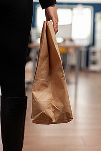 女商人在外卖午餐时间拿着送货外卖食品餐单纸袋