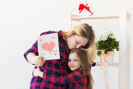 母亲节、假期和家庭假期-母亲拿着她可爱的女儿的贺卡。