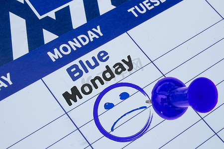 蓝色星期一的日历特写，蓝色黑色文本，带有悲伤的脸和蓝色的别针