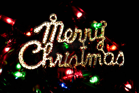 圣诞快乐在黑暗的背景与灯光散景闪闪发光的背景礼物新年。