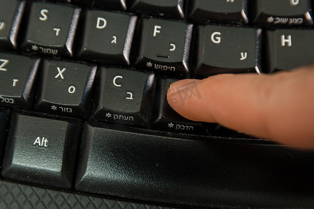 男子在键盘上用希伯来语和英语字母打字