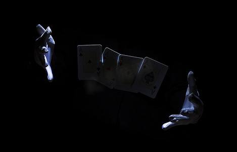 魔术师摄影照片_魔术师的手用扑克牌表演魔术。