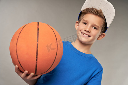 鼠年拜年海报摄影照片_戴帽子的快乐男孩拿着篮球
