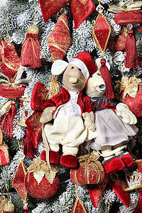 在鼠年的前夕，在新年树的背景下，一对装饰玩具老鼠喜庆地穿着红色衣服。