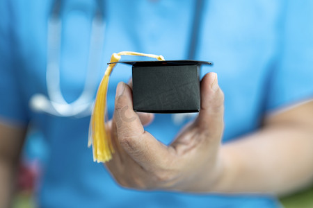 亚洲医生在医院病房学习毕业间隙帽子：聪明聪明的天才教育医学理念。