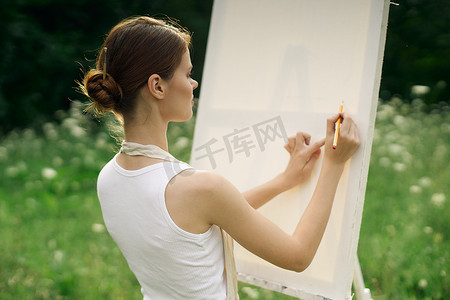 穿着围裙的女艺术家在大自然中画画艺术