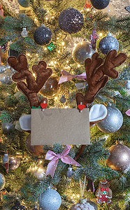 圣诞邮件信封上有空白字母，装饰树上有驯鹿耳朵，复制空间接近、背景、假日概念