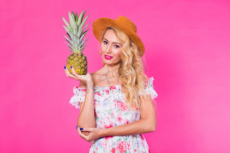 粉色背景菠萝的时尚肖像年轻美女