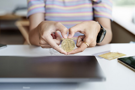 加密货币是数字货币，女性手持可用于计算机的比特币来投资来自未来数字或想象世界的资产。 
