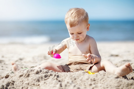 男孩在海边玩沙