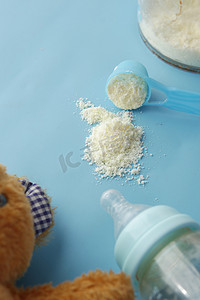 关闭婴儿奶粉和勺子在瓷砖背景上。