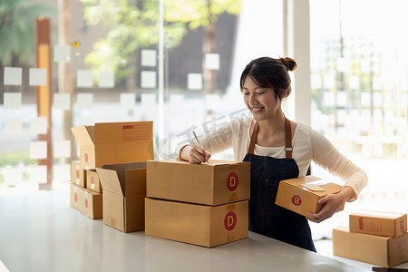 年轻的亚洲小企业主在家庭办公室工作，记录采购订单。