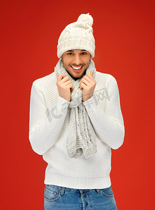 围巾摄影照片_穿着温暖毛衣、帽子和围巾的英俊男人