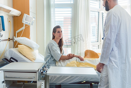 等待圆摄影照片_病人在病床上等待医生看望她