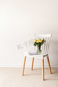 简约的家居内饰，配有时尚的椅子、新鲜玫瑰花束和书籍