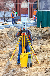 道路服务工程师在建筑工地使用激光水平仪。