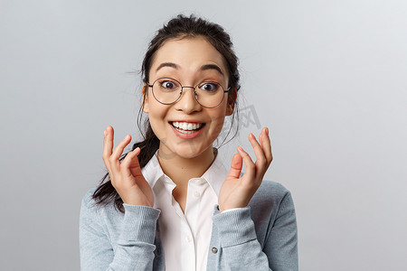 升职背景摄影照片_高兴、惊讶的戴眼镜的亚洲女性的特写肖像，为人感到高兴，听到很棒的消息，意识到发生了好事，她赢了或升职了，高兴地笑着