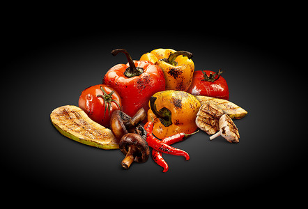 黑色背景上烤美味的红黄甜椒、西红柿、西葫芦、蘑菇、辣椒和半大蒜。
