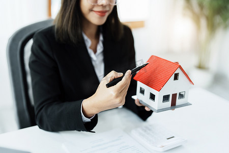 法律、协议、合同、抵押贷款，女人拿着笔，指着房子看利率，要求买房前评估风险限额