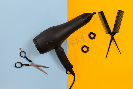 烘干机摄影照片_在理发店用剪刀、烘干机和工具在蓝色和黄色纸背景顶视图模型上造型头发