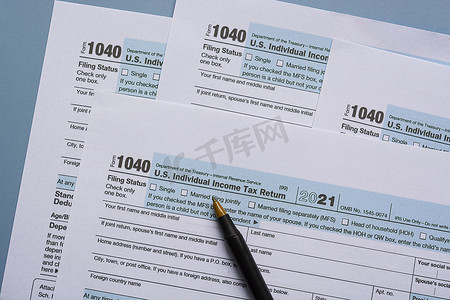 个人所得税摄影照片_纳税表格 1040。美国个人所得税申报表在桌子上。