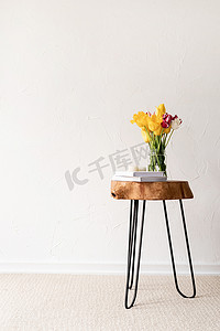 简约的家居内饰，配有时尚的木质咖啡桌和新鲜郁金香花束