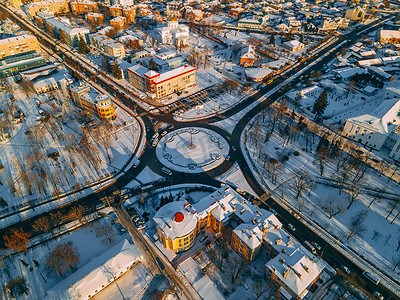 汽车天线摄影照片_冬季日落时欧洲小城市环形交叉路口与圆形汽车的鸟瞰图