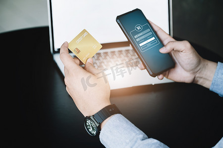网上购物和互联网支付，亚洲男性正在使用信用卡和手机在数字世界中网上购物或办事。