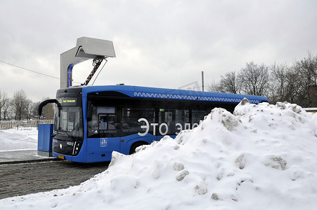 电动大巴摄影照片_电动公交车在充电站充电。