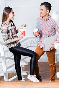 年轻男女在工作休息时一边喝咖啡一边聊天