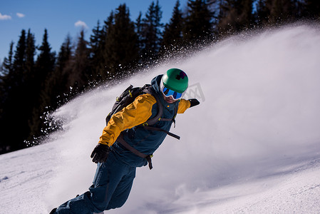 冬天骑行摄影照片_滑雪板跑下斜坡并自由骑行