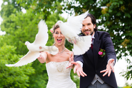 和平的白鸽摄影照片_婚礼上一对新人与飞翔的白鸽