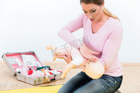 课程培训摄影照片_参加急救课程的妇女在婴儿 d 上练习婴儿的复苏
