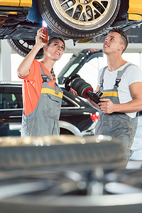 经验丰富的女性汽车修理工与修理店的同事