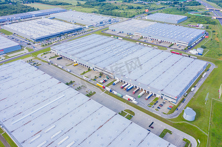 工厂仓库摄影照片_大型物流园区的鸟瞰图，配有仓库、装载中心和许多半挂车卡车。