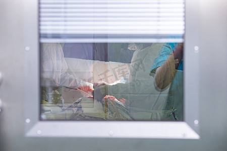 手术室玻璃后面有一群外科医生。