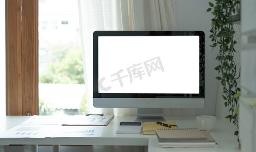 工作空间摄影照片_最小办公室内的空白屏幕台式电脑，配有装饰和复印空间