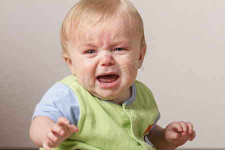 哭泣摄影照片_年幼的孩子心烦意乱，哭泣。