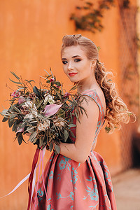 一位年轻的模特女孩穿着漂亮的裙子，手里拿着一束鲜花，在法国的乡村。