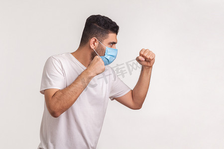 戴着面具的男子的侧视图，拳头紧握，与传染病作斗争