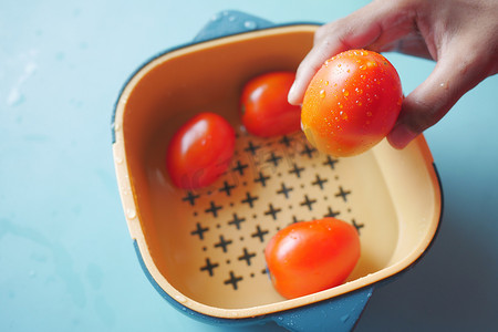 用塑料碗中的水清洗新鲜番茄