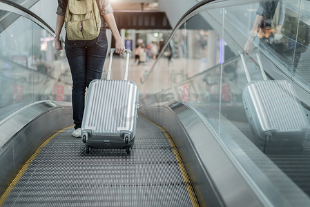 关闭带着行李箱乘飞机前往世界各地的女旅客的下半身。