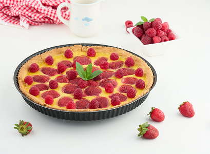 白草莓摄影照片_白桌上有红草莓和覆盆子的圆形乳蛋饼
