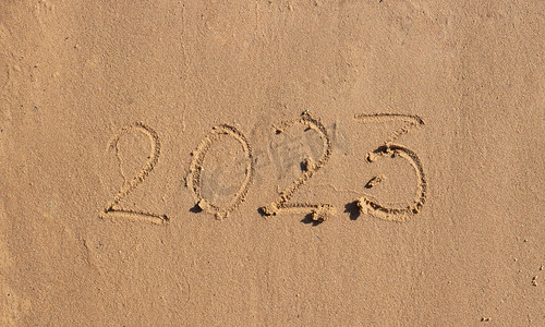 2023喜庆摄影照片_沙滩上的沙子上写着数字2023。