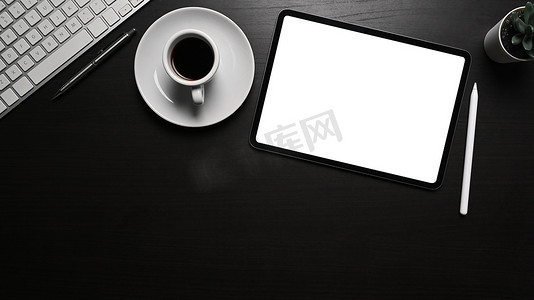 黑色办公桌上的顶视图数字平板电脑、手写笔和咖啡杯。