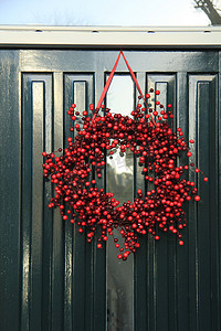 圣诞花环摄影照片_门上装饰着浆果圣诞花环
